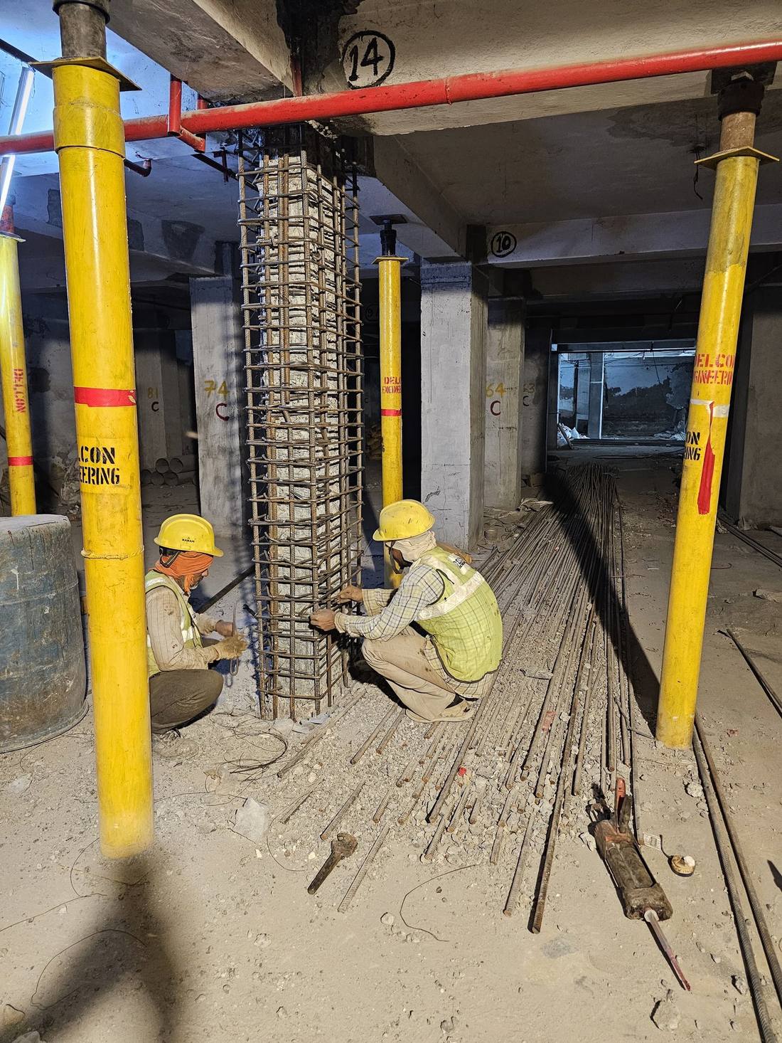 Site engineers tying a rebar cage around a column