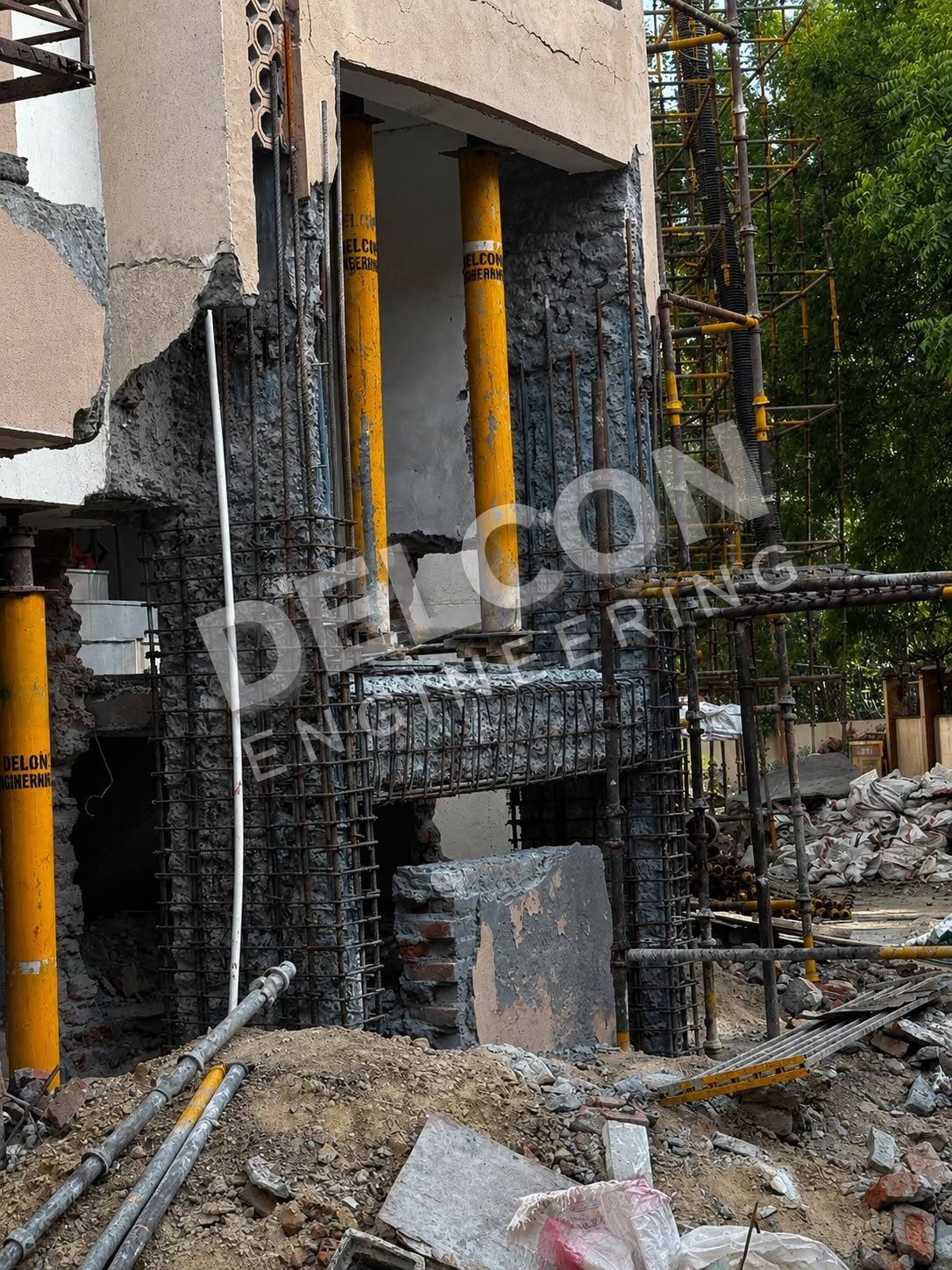 Multiple retrofitted columns with new rebar jackets on an active site