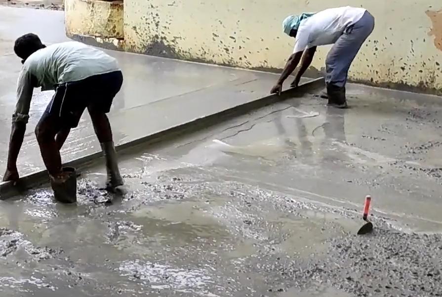 Workers finishing a fresh concrete road slab